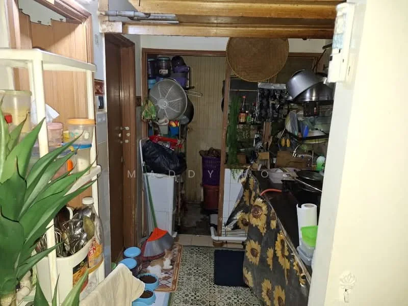 Kitchen features: wooden ceiling, wall-mounted ceiling fan, tile flooring, wooden cabinets, metal sink, stainless-steel cooking utensils, various kitchen appliances, countertop with clutter, floral-patterned curtains, open shelving, kitchenware storage, baskets for storage.