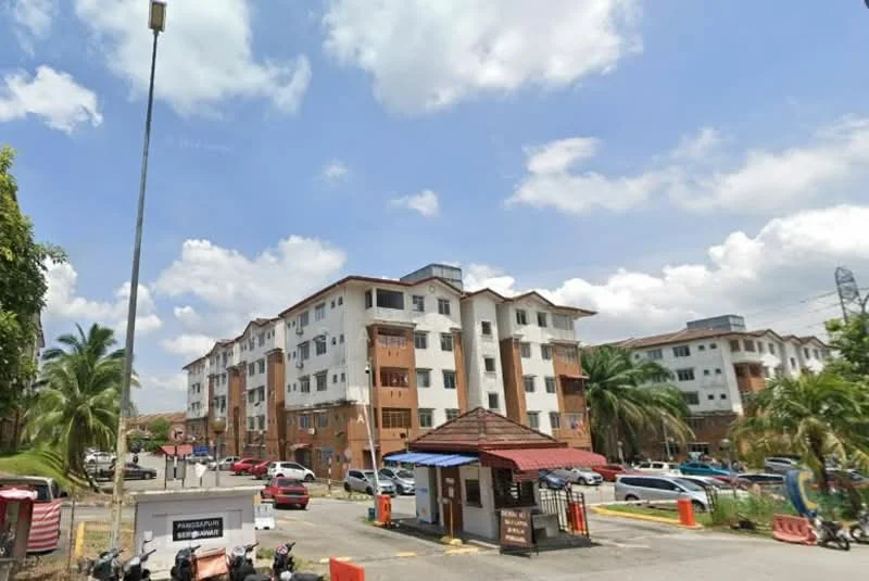Exterior type: low-rise apartment block; features: cream painted facade, red brick accents, flat roof, approximately 4-storey, manicured lawn, palm trees, parking lot, guard house at entrance, surrounded by greenery, driveway with interlocking pavers; style: modern.
