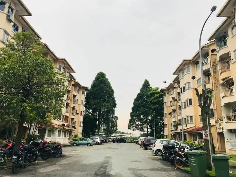 Exterior type: low-rise apartment block; features: cream painted facade, 3-storey low-rise, manicured lawn, mature trees, open-air parking lot, surrounded by greenery; style: modern.