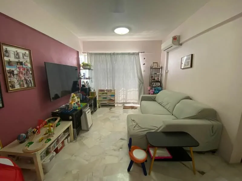 Living features: light grey fabric sofa, marble flooring, pink accent wall, white painted walls, large window with sheer curtains, wall-mounted TV, TV console, decorative wall frames, air conditioning unit, coffee table, children's play area with toys; style: modern.