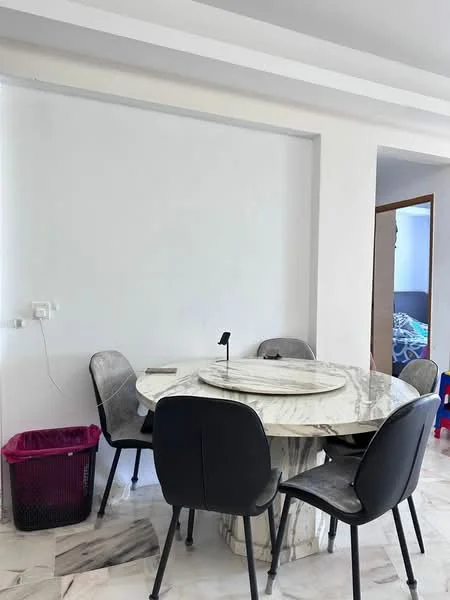 Dining features: round marble dining table, 4 black dining chairs, white painted walls, marble flooring, wall-mounted electrical outlet, wastebasket; style: modern.