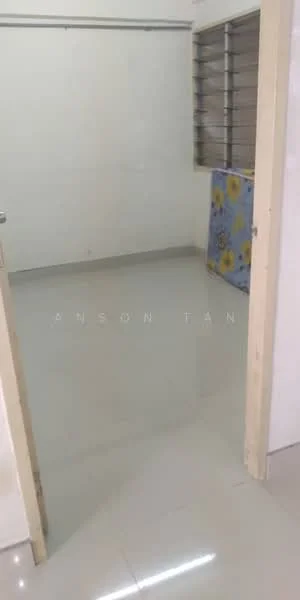Room features: white painted walls, glossy tile flooring, window with metal grille, plain ceiling, door frame, blue floral-patterned fabric, empty space; style: minimalist.