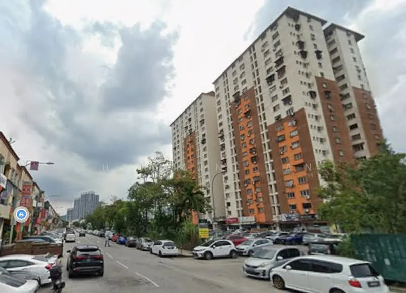 Exterior type: mid-rise condominium; features: orange and white painted facade, multiple storeys, balconies visible, surrounded by trees, street view with parked cars, urban setting, cloudy sky; style: modern.