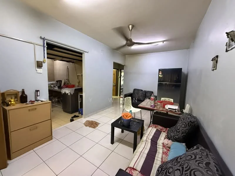 Living features: white painted walls, tile flooring, 5-blade ceiling fan, sofa with patterned cushions, coffee table, dining table, fridge, decorative items on table, open layout to kitchen, window with no treatment, light source from ceiling, area rug. Kitchen features: tile flooring, open layout to living room, visible kitchen appliances, cooking area, storage cabinets.