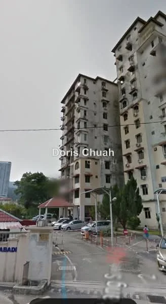 Exterior type: mid-rise condominium; features: concrete facade, multiple storeys, balconies on upper floors, parking area visible, surrounding greenery, entrance gate, guard house at entrance; style: modern.