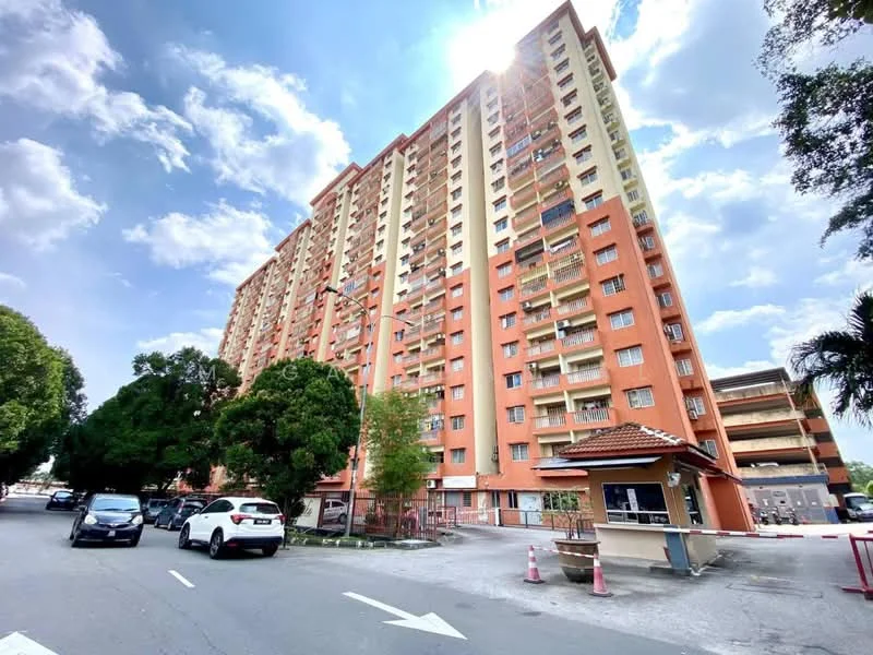 Exterior type: high-rise condominium; features: orange painted facade, multiple storeys, balconies on each floor, surrounded by greenery, parking deck visible, guard house at entrance, driveway with interlocking pavers, street view with vehicles, clear blue sky, sunlight reflecting off the building; style: modern.