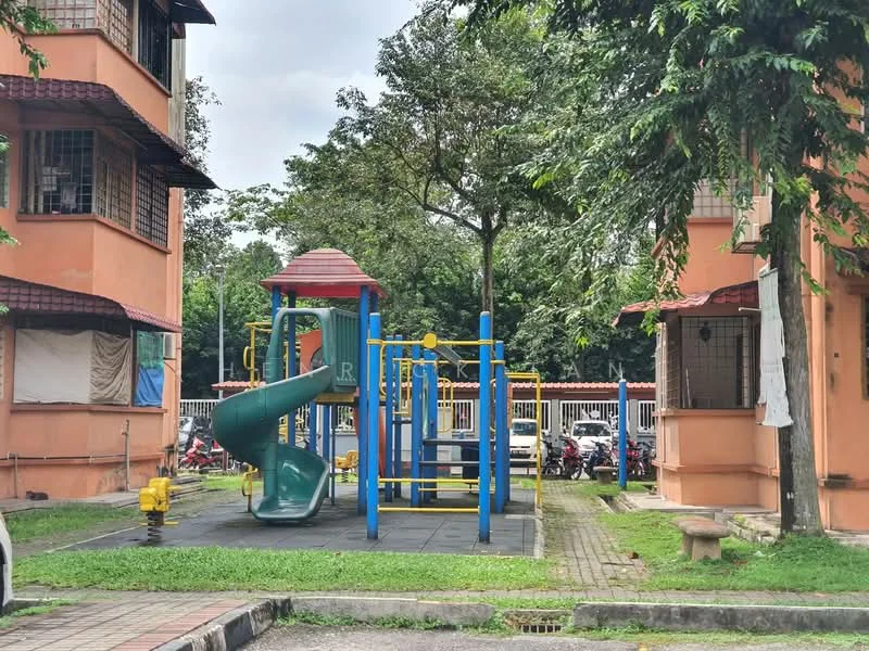 Exterior type: low-rise apartment block; features: playground with slide and climbing structure, manicured lawn, paved walkway, surrounding trees, parking area visible, two adjacent apartment buildings, balconies with window treatments; style: modern.