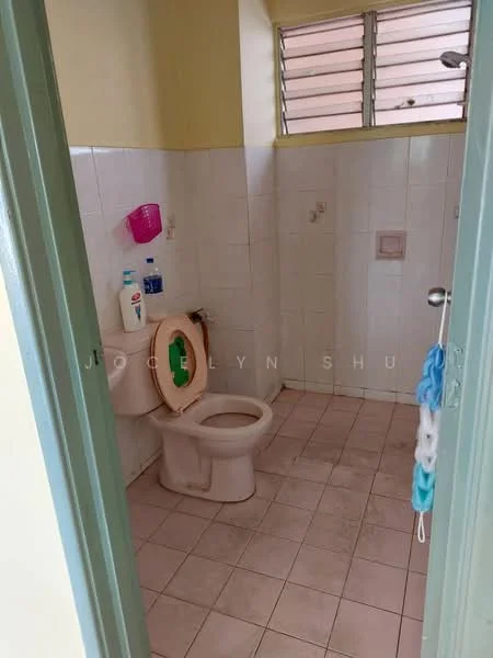 Bathroom features: white tiled walls, pink tiled flooring, one-piece toilet, sink with faucet, window with metal grilles, toilet paper holder, soap dispenser, shower area with wall tiles.