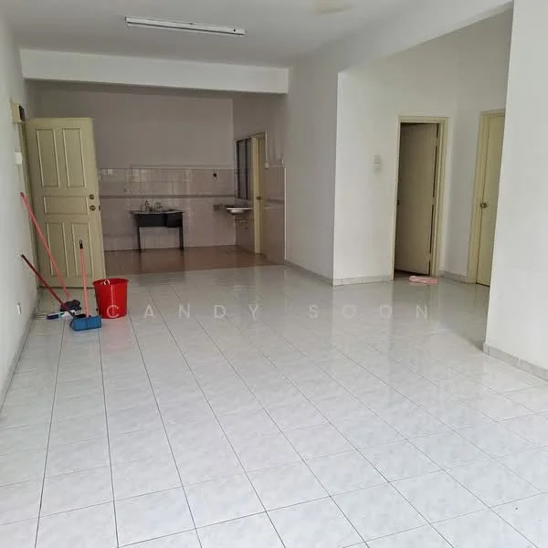 Room features: white painted walls, glossy white floor tiles, ceiling lights, open layout, kitchenette area with sink, doorway leading to other rooms, cleaning supplies visible (mop, bucket), no visible furniture; style: minimalist.