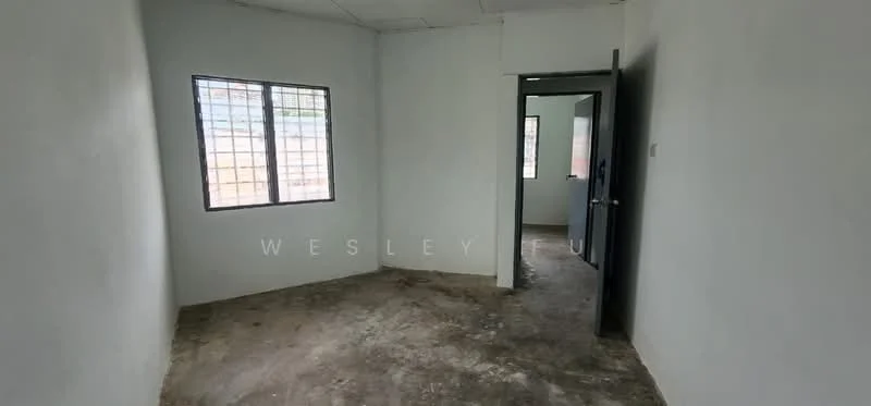 Room features: white painted walls, concrete flooring, single window with metal grille, doorway leading to another room, no visible furniture or decor; style: minimalist.