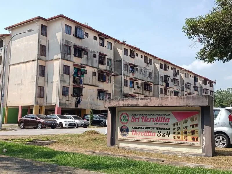 Exterior type: low-rise apartment block; features: weathered concrete facade, multiple balconies, visible laundry hanging on balconies, ground-level parking area, signboard with property name, surrounding greenery, multiple car parking spaces; style: traditional.