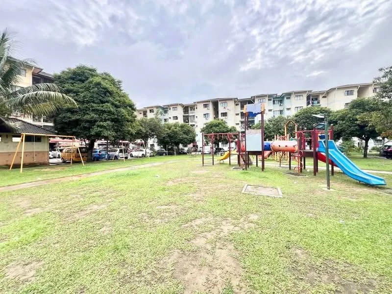 Exterior type: low-rise apartment block; features: playground with slides and climbing structures, manicured lawn, mature trees, parking area visible, surrounding residential buildings, open green space; style: modern.