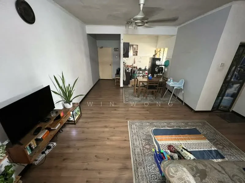 Living features: wooden flooring, white painted walls, 5-blade ceiling fan, sofa in light grey, coffee table, TV console, wall-mounted TV, area rug with geometric pattern, decorative plant, dining table with chairs, high chair, open layout to kitchen, doorway leading to hallway; style: modern.