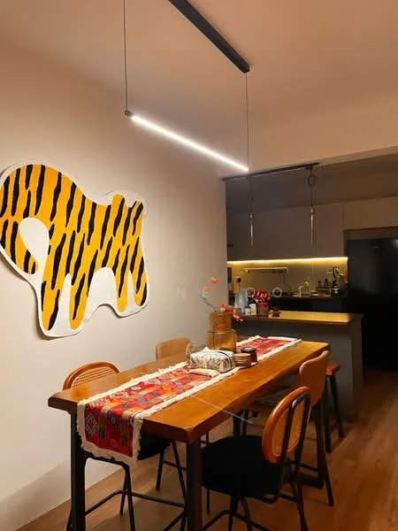 Dining features: wood dining table, black dining chairs, decorative table runner, abstract wall art with tiger stripes, pendant lighting, open kitchen layout, kitchen countertop with bar stools, kitchen appliances visible in background, wooden flooring, wall-mounted cabinetry, recessed lighting; style: modern.