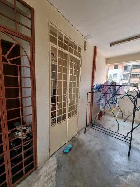 Laundry features: concrete flooring, metal drying rack, sliding door with grille, wooden door with grille, light fixture on ceiling, walls painted in neutral color, open space for laundry activities.