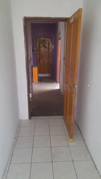 Room features: white painted walls, tiled flooring, wooden door, door frame, purple accent wall, visible hallway, light source from ceiling, open doorway.