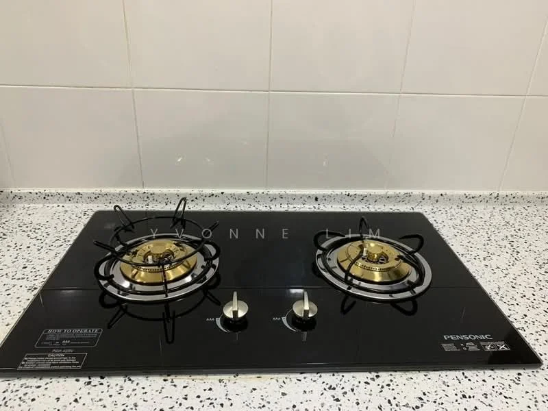 Kitchen features: black glass cooktop, two gas burners, gold burner caps, stainless-steel knobs, speckled granite countertop, white tiled backsplash; style: modern.