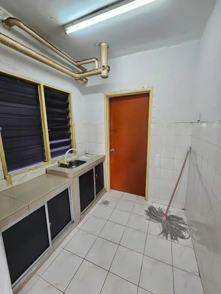 Kitchen features: single-bowl stainless-steel sink, chrome faucet, white tiled walls, white tiled flooring, wood cabinetry with glass doors, window with black blinds, door with yellow frame, exposed plumbing pipes, mop on the floor.
