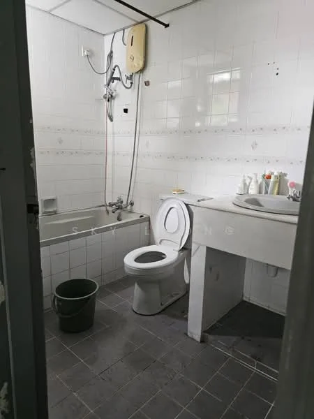 Bathroom features: white tiled walls, grey tiled flooring, bathtub with showerhead, toilet, sink with cabinet, mirror above sink, wall-mounted water heater, bucket.