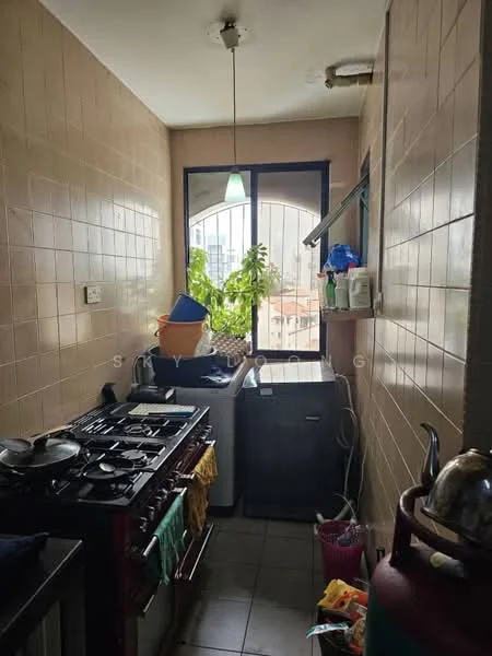 Kitchen features: gas stove with 4 burners, stainless-steel sink, window with view of exterior, grey tiled flooring, cream tiled walls, hanging light fixture, refrigerator, washing machine, kitchen cabinets, plant on windowsill, cleaning supplies on countertop, colorful dish towels; view: city.