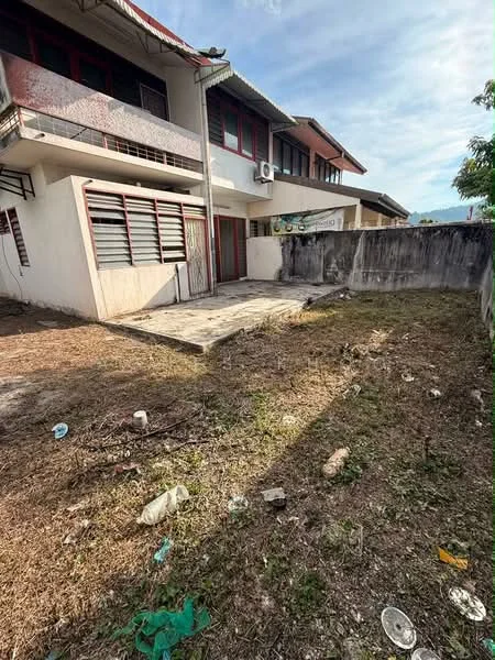 Exterior type: semi-detached house; features: two-storey building, red window frames, air conditioning unit on wall, patio area, fenced yard, overgrown grass, debris on ground, concrete flooring, exterior wall with white paint, roof with tiles; style: modern.