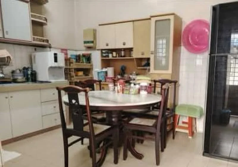 Kitchen features: light wood cabinetry, white laminate countertops, round dining table, 4 wooden dining chairs, stainless-steel microwave, white refrigerator, built-in oven, ceramic tile flooring, sink with faucet, open shelving, kitchen utensils visible, green stool, black tiles on wall, window with natural light.
