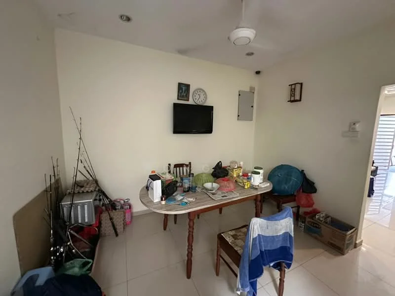 Room features: white painted walls, glossy tile flooring, ceiling fan, wall-mounted TV, round dining table, wooden dining chairs, various household items on table, boxes and bags in the corner.