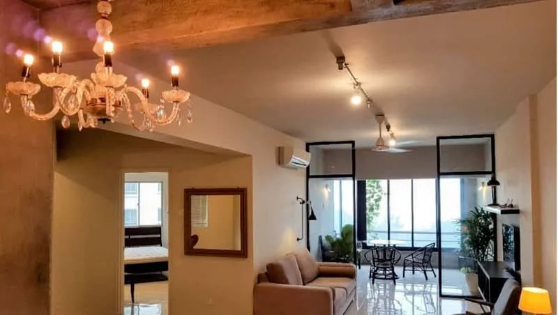 Living features: chandelier with crystals, exposed beams on ceiling, recessed downlights, floor-to-ceiling windows, sliding glass door, light-coloured walls, polished tile flooring, sofa in beige, coffee table, TV console, area rug, ceiling fan; style: modern; view: garden. Room features: mirror, wall-mounted air conditioning unit.