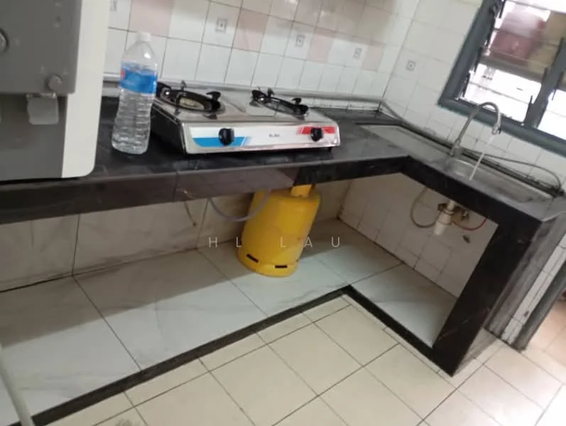 Kitchen features: black marble countertop, white tiled backsplash, gas stove with two burners, water bottle on countertop, yellow gas cylinder, white tiled flooring, sink with faucet, open shelving below countertop.