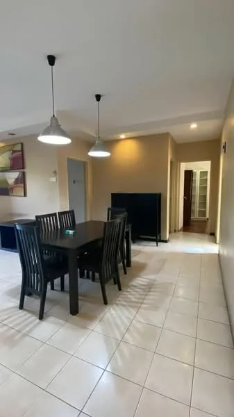 Dining features: rectangular dining table with black finish, 6 black dining chairs, pendant lighting fixtures, white tiled flooring, cream painted walls, wall-mounted TV, open doorway leading to another room, decorative wall art; style: modern.