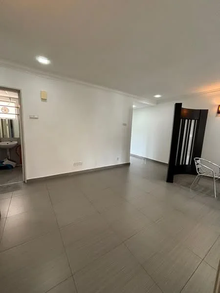 Room features: white painted walls, grey tiled flooring, recessed downlights, wall-mounted light fixture, open layout, doorway leading to another room, partition wall, no visible furniture; style: modern.