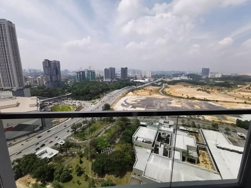 Exterior type: high-rise condominium; features: glass balcony railing, city skyline view, surrounded by greenery, urban landscape, highway visible, construction site in the background; style: modern.
