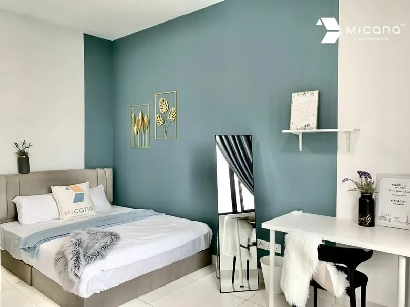 Bedroom features: queen-size bed with upholstered headboard, white bedding, decorative throw blanket, green accent wall, white painted walls, floor-to-ceiling mirror, white desk with chair, decorative wall art, window with sheer curtains, tile flooring; style: modern.