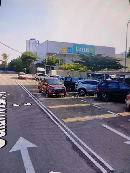 Exterior type: shopping mall; features: large commercial building, parking lot with multiple vehicles, signage for Lotus's, surrounding greenery, roadway with directional signage, urban setting, multiple-storey structure; style: modern.