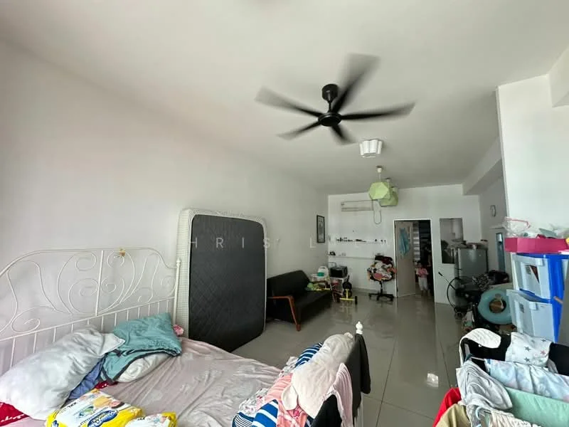 Room features: white painted walls, grey tiled flooring, 5-blade ceiling fan, wall-mounted air conditioning unit, double bed with white metal frame, black sofa, clothes on bed, laundry basket, open doorway to another room, green ceiling light, various items on shelves; style: minimalist.