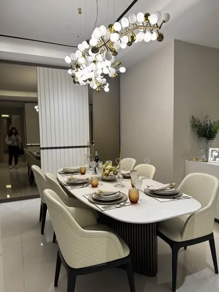 Dining features: 6-seater dining table with marble top, upholstered dining chairs in cream, gold and white chandelier, decorative table settings with plates and glasses, neutral wall color, polished tile flooring, built-in cabinetry in the background, decorative plants on the side, soft ambient lighting; style: modern.
