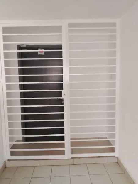 Room features: white painted walls, black door, metal grille door, tile flooring, neutral color scheme, light switch, door handle, security features; style: modern.