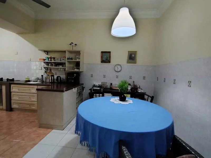 Kitchen features: blue round dining table, black dining chairs, white walls, cream tiled backsplash, wood cabinetry, stainless-steel appliances, kitchen counter, pendant light, clock on wall, decorative plant on table; style: traditional.