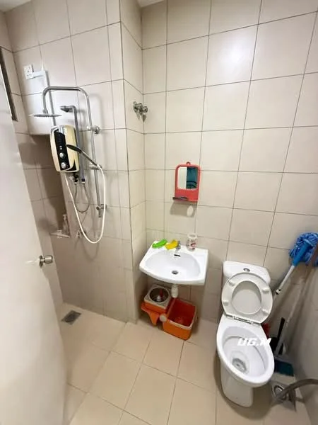 Bathroom features: cream tiled walls, cream tiled flooring, shower with handheld showerhead, toilet, single-sink vanity with white cabinet, mirror above sink, soap dispenser, cleaning supplies, shower caddy, wall-mounted shower control, towel rack.