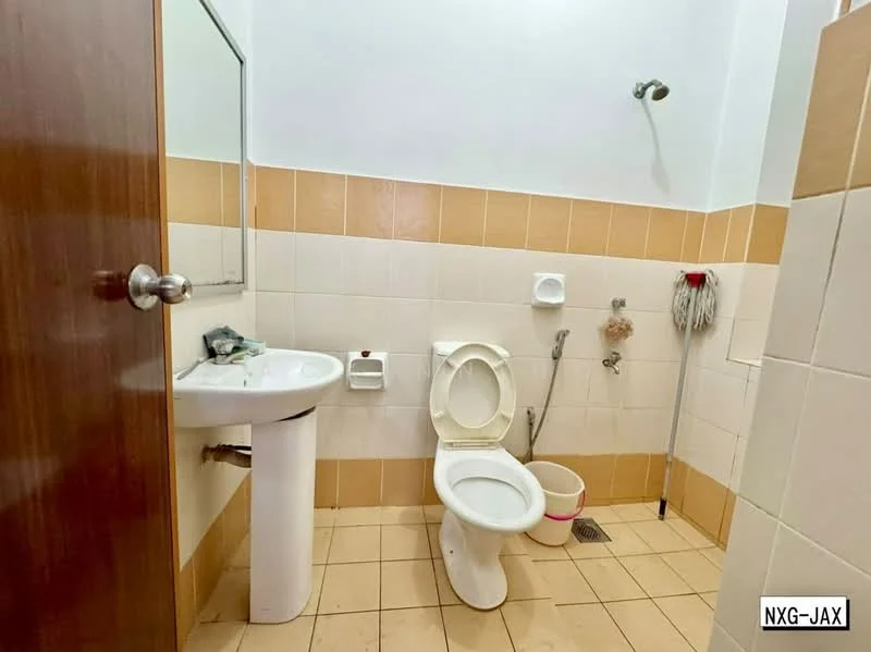 Bathroom features: white ceramic toilet, single-sink vanity with pedestal, chrome basin mixer faucet, mirror above sink, shower head with wall-mounted fixture, tile flooring, beige wall tiles, white wall tiles, mop and bucket visible, drain on floor.