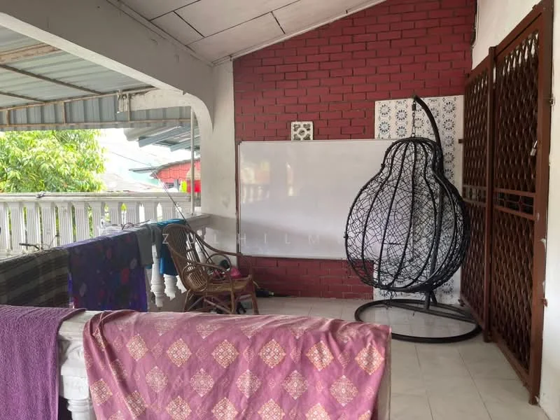 Room features: white walls, red brick accent wall, tiled flooring, ceiling with exposed beams, large whiteboard, decorative wall art, hanging wicker chair, wooden railing, curtains, various textiles draped over furniture.