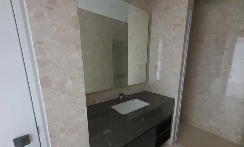 Bathroom features: single-sink vanity with dark stone countertop, white rectangular sink, framed mirror, light beige marble wall cladding, light beige marble flooring, modern faucet, built-in cabinetry under sink; style: modern.