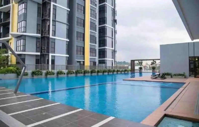 Exterior type: high-rise condominium; features: infinity pool, pool deck with loungers, glass curtain wall facade, grey painted facade, yellow accent panels, landscaped garden area, surrounded by greenery; style: modern.