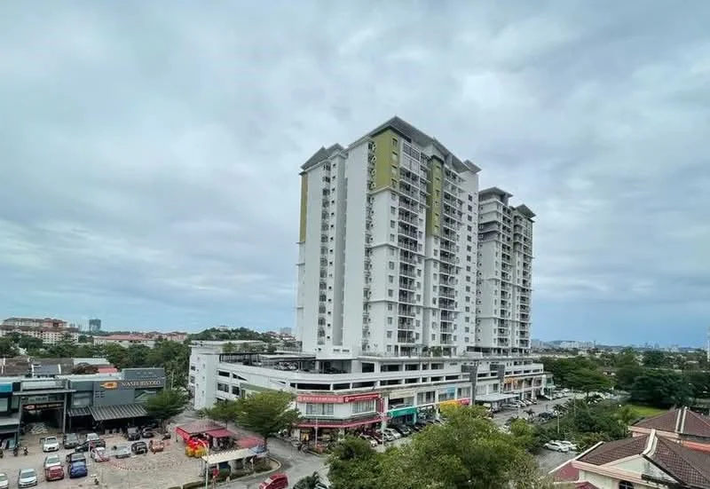 Exterior type: high-rise condominium; features: white painted facade, glass curtain wall, recessed balconies, approximately 10-storey high-rise, surrounded by mature greenery, commercial units at ground level, parking area visible, urban context with nearby shops; style: modern.