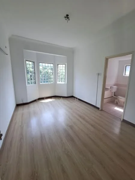 Room features: white painted walls, laminate flooring, three-panel bay windows, natural light from windows, doorway leading to bathroom, ceiling light fixture.