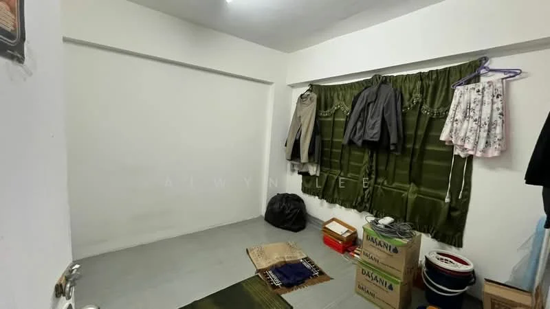 Room features: white painted walls, grey tiled flooring, green curtains, clothes hanging on hooks, boxes on the floor, area rug, window with no visible view, minimal furniture; style: minimalist.