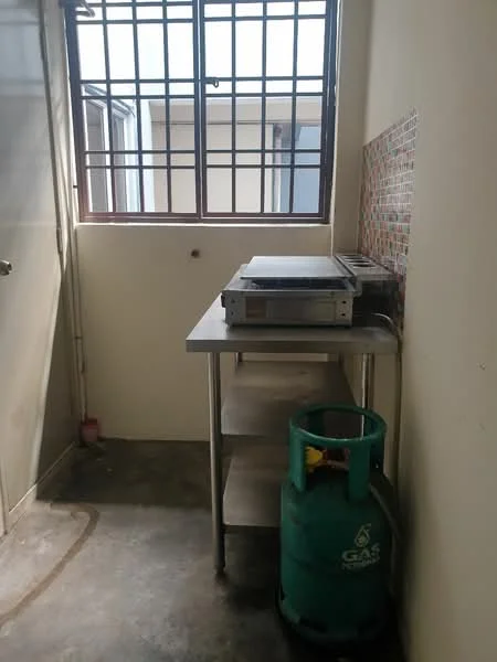 Room features: stainless-steel work table, gas cylinder, concrete flooring, window with metal grille, wall with tile backsplash.