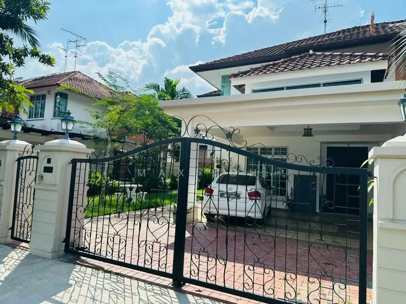 Exterior type: detached bungalow; features: gated entrance with wrought iron gate, paved driveway, manicured lawn, mature trees, two-storey structure, red tiled roof, front porch, visible car parked in driveway, outdoor lighting fixtures, surrounded by greenery; style: modern.