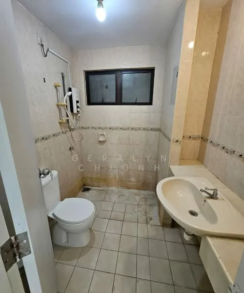 Bathroom features: white tiled walls, cream tiled accents, white ceramic toilet, single-sink vanity with countertop, chrome basin mixer faucet, mirror above sink, shower area with wall-mounted showerhead, window for natural light, light fixture on ceiling, grey floor tiles.