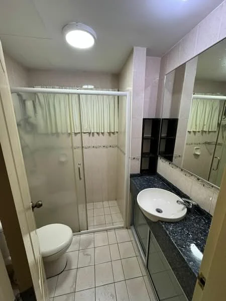 Bathroom features: glass shower enclosure, chrome shower head, single-sink vanity with granite countertop, round basin sink, mirror above sink, white toilet, tile flooring, light fixture on ceiling, beige tiled walls, built-in shelving unit; style: modern.